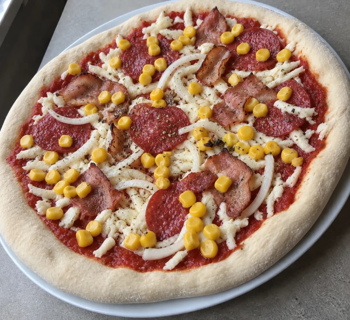 Salami und Speck mit Mais vor dem Backen